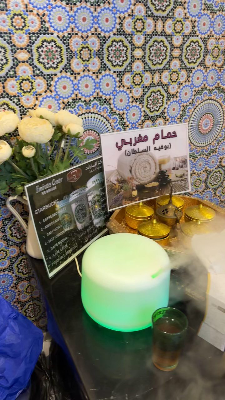 Moroccan bath area with mosaic tiles, flowers and a bowl of natural clay